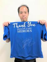 　サイン入りした青色Ｔシャツを手に持つ青柳（球団提供）