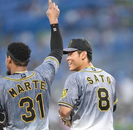 ４回、マルテと談笑しながら守備位置へ向かう佐藤輝＝神宮（撮影・飯室逸平）