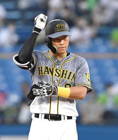 ベンチに向かって手を上げる佐藤輝　