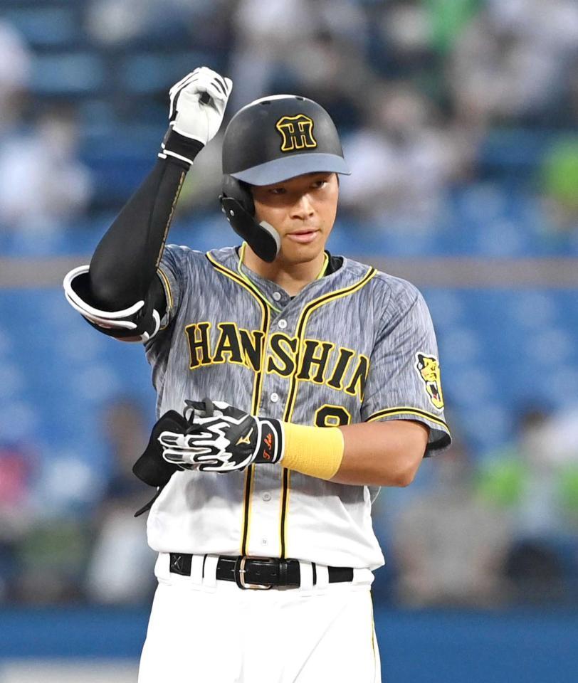 ベンチに向かって手を上げる佐藤輝　