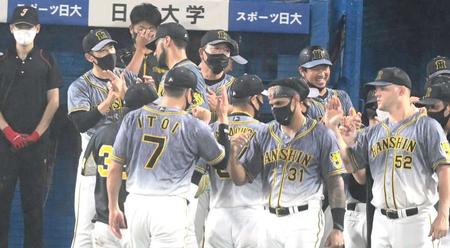 　鮮やかな逆転勝ちでナインを迎える矢野監督（左）