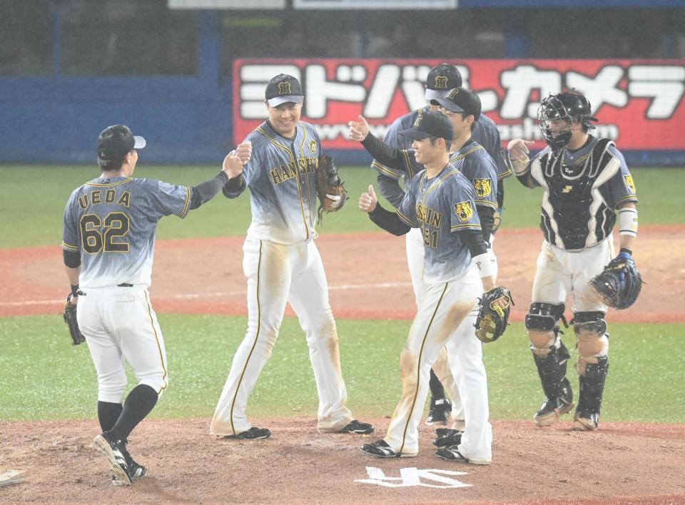 　試合に勝利し、マウンドでタッチする大山（左から２人目）ら阪神ナイン