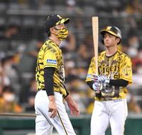 　７回を終え、選手交代を告げに行く矢野監督。右は近本