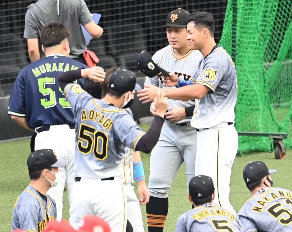 村上、岡本和らと談笑する佐藤輝（撮影・飯室逸平）