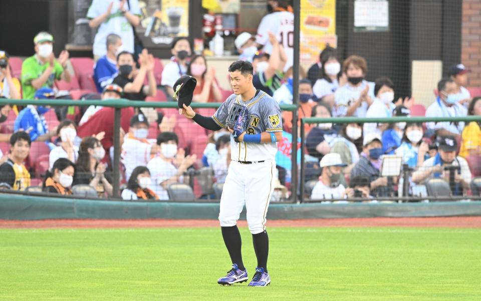 　２回、先制ソロを放ち、守備時にファンの拍手に帽子を取って応える阪神・佐藤輝（撮影・高石航平）