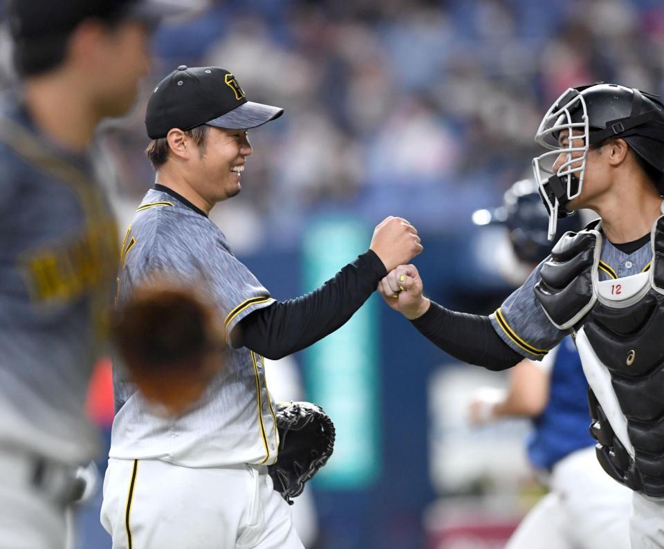 　４回のピンチを無失点で切り抜けた西勇は坂本（右）とタッチを交わす