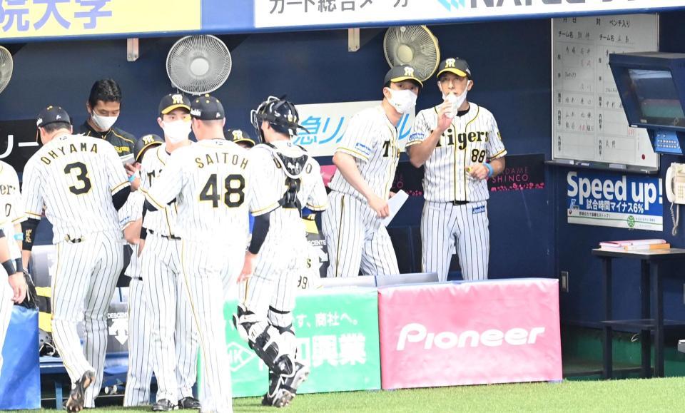 　９回、ベンチで新井コーチと話す矢野監督（右端）＝撮影・飯室逸平