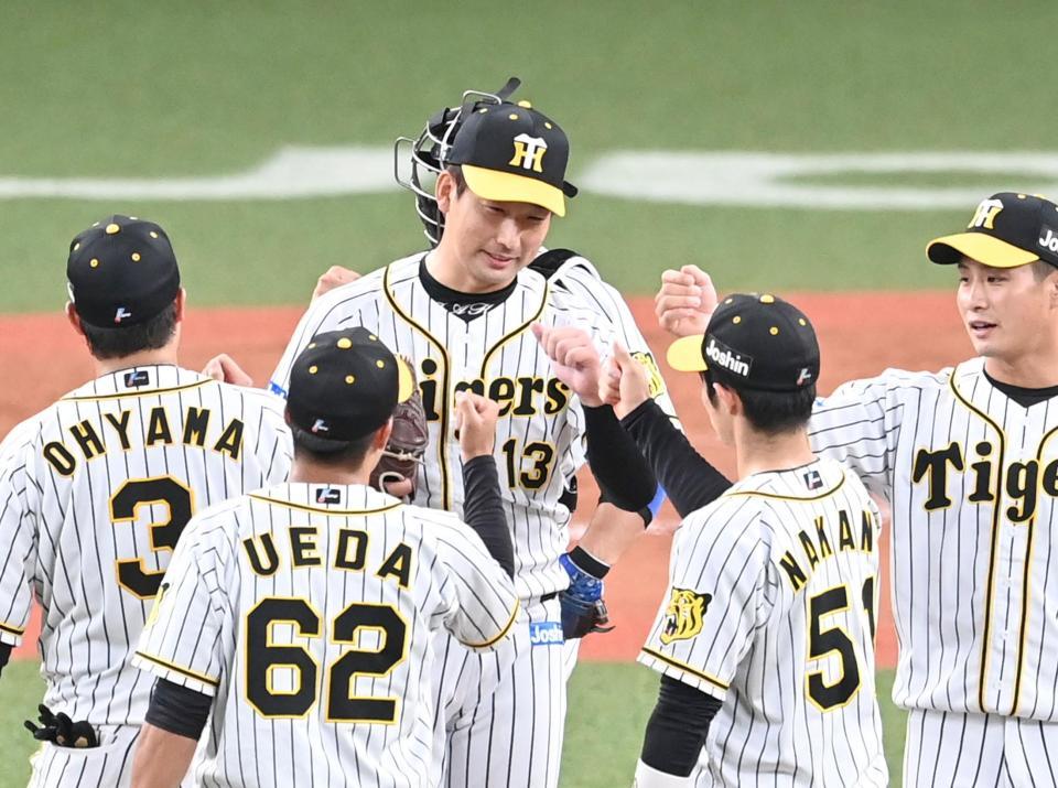 　９回、最後を締め勝利のタッチを交わす岩崎（中央）