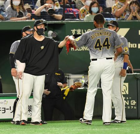 　７回を無失点に抑えたアルカンタラ（右）とタッチを交わす青柳（撮影・西岡正）