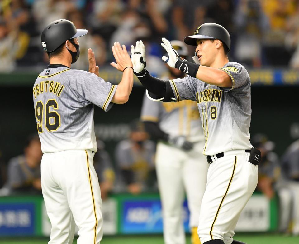 　３回、ソロを放ち、筒井コーチ（左）とタッチを交わす佐藤輝（撮影・西岡正）