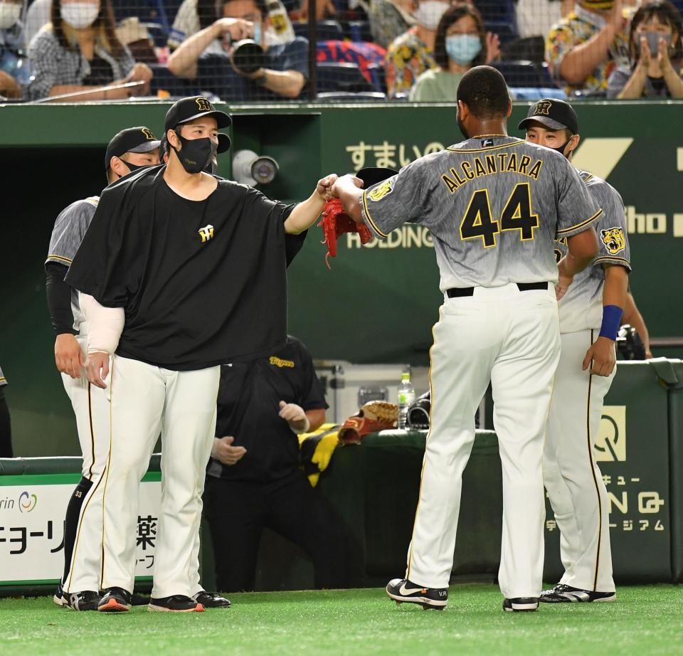 　７回を無失点に抑えたアルカンタラ（右）とタッチを交わす青柳（撮影・西岡正）