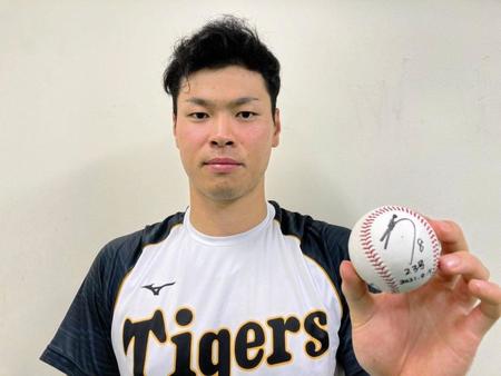 ２３号記念ボールを持つ阪神・佐藤輝明＝阪神タイガース提供