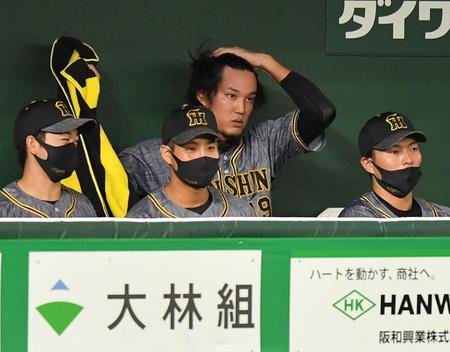 　１９日のＤｅＮＡ戦、勝ち越しを許して降板し、ベンチで頭をかく藤浪（奥）＝撮影・西岡正
