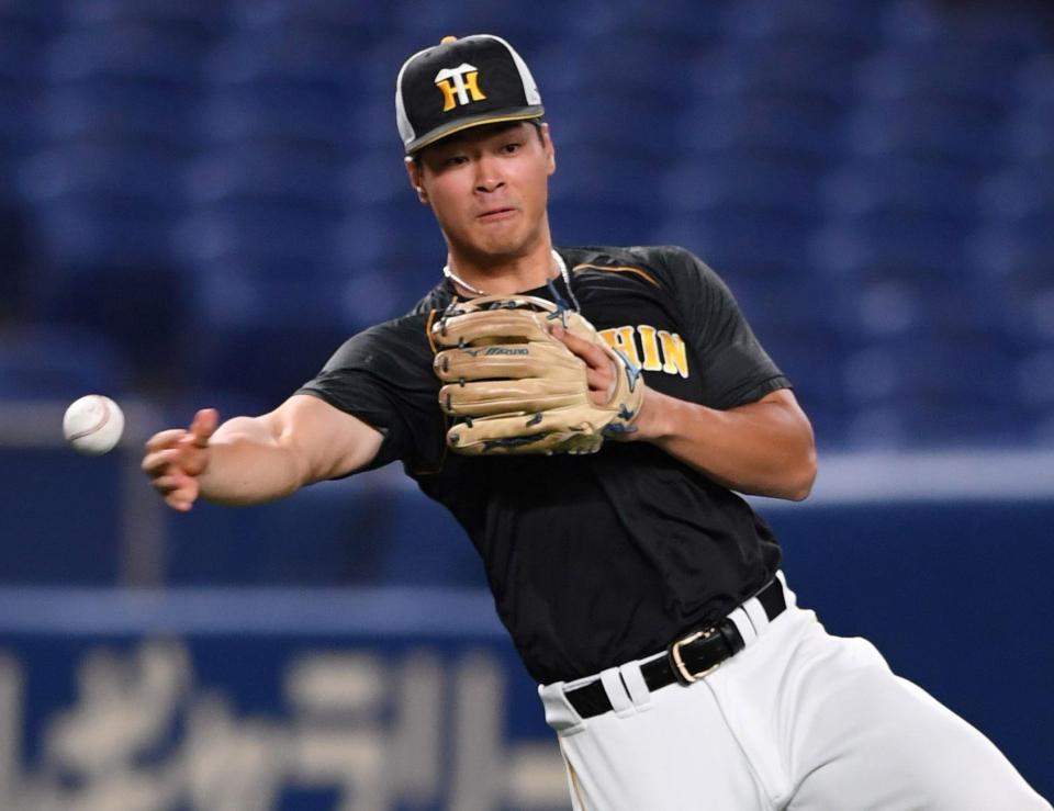 　三塁でノックを受け、送球する佐藤輝（撮影・田中太一）