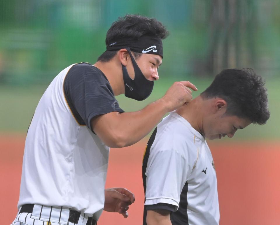 試合前、中野（右）の髪型をイジる！？佐藤輝（撮影・高部洋祐）