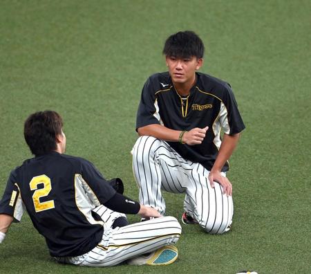 　練習中、梅野（左）と話をする阪神・伊藤将＝京セラドーム大阪（撮影・山口登）