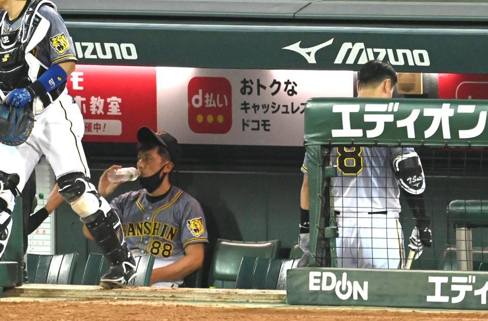 　６回、阪神・佐藤輝は見逃し三振に倒れベンチに戻る（左は阪神・矢野監督）＝マツダスタジアム（撮影・山口登）