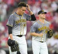 １回、３点を先制されベンチへ戻る阪神・秋山拓巳。右は失策した阪神　ジェリー・サンズ＝マツダスタジアム（撮影・田中太一）