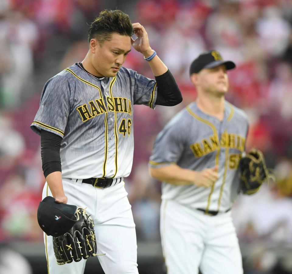 １回、３点を先制されベンチへ戻る阪神・秋山拓巳。右は失策した阪神　ジェリー・サンズ＝マツダスタジアム（撮影・田中太一）