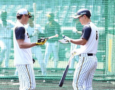 　早出特打で佐藤輝にバットを手渡す糸井（撮影・飯室逸平）