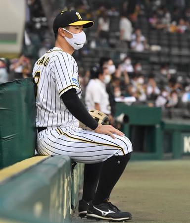 　試合前、ベンチ前で座る佐藤輝（撮影・北村雅宏）