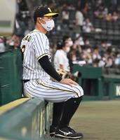 　試合前、ベンチ前で座る佐藤輝（撮影・北村雅宏）