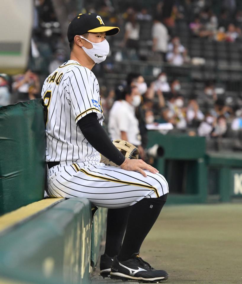 　試合前、ベンチ前で座る佐藤輝（撮影・北村雅宏）