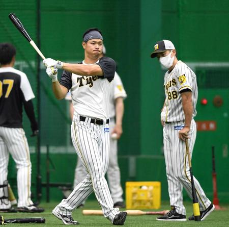 　矢野監督（右）の指導を受け、素振りをする佐藤輝