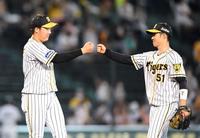 チームの勝利に貢献した大山（左）と中野はタッチを交わす＝甲子園（撮影・田中太一）