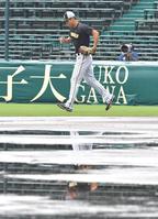 水たまりを横目に外野ノックへ向かう阪神・佐藤輝＝甲子園球場（撮影・吉澤敬太）