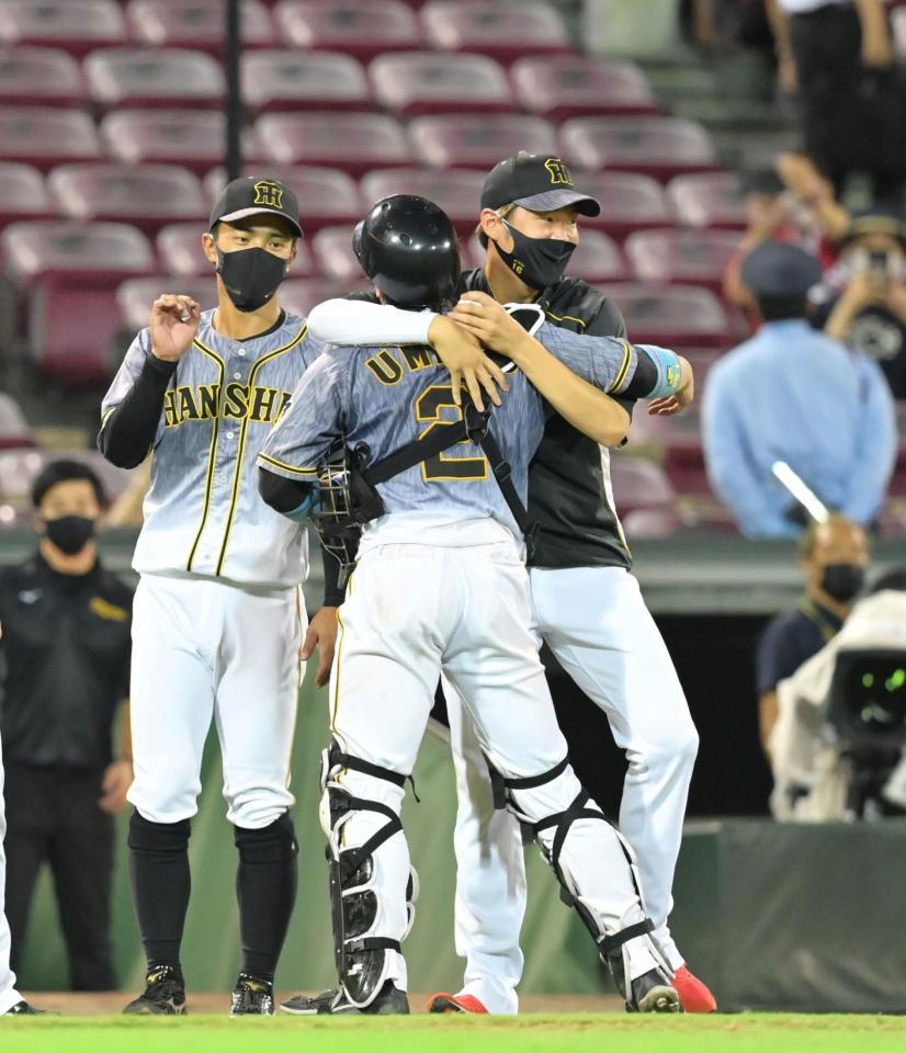 　チームが勝利して自身の１００勝目が決まり、梅野と抱き合って喜ぶ西勇（撮影・立川洋一郎）