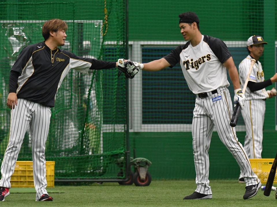 　西勇（左）とグータッチをする佐藤輝（撮影・佐々木彰尚）