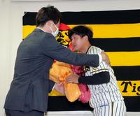 　引退会見で俊介（右）は新井コーチから花束を贈られる