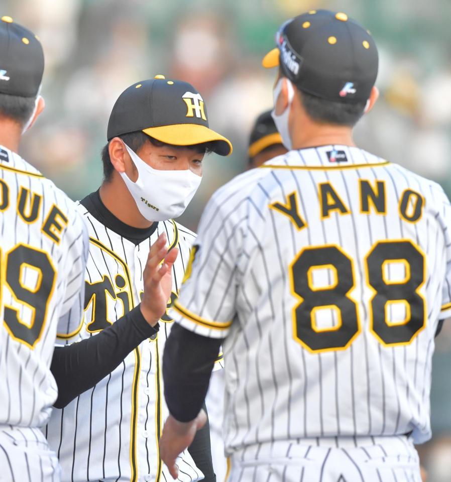 　今季初勝利を挙げ、矢野監督（右）とタッチを交わす高橋（撮影・吉澤敬太）