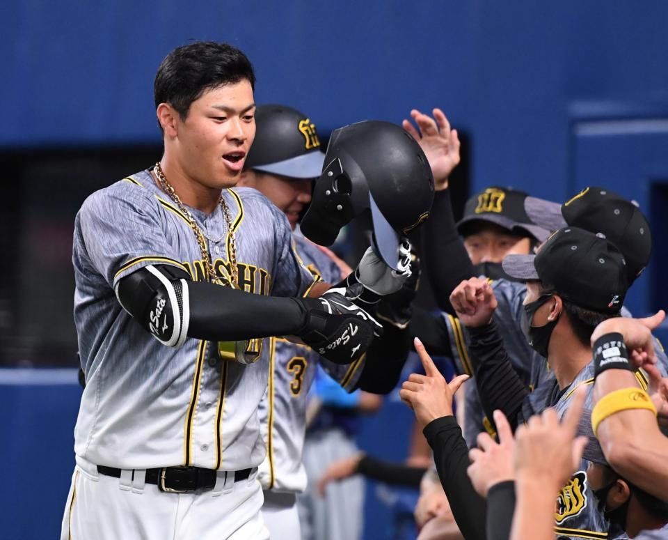 ４回、最初はホームランの判定で、ナインから祝福を受ける佐藤輝。その後リクエストでファウルとなる（撮影・飯室逸平）