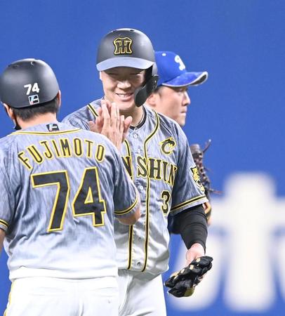 　８回、笑顔でタッチを交わす大山悠輔（撮影・飯室逸平）