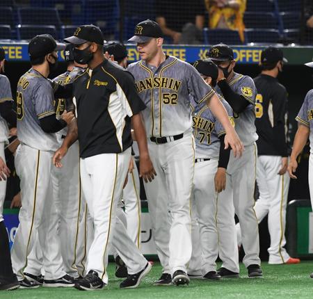 　矢野監督（左）に迎えられる阪神・サンズ（中央）＝東京ドーム（撮影・佐藤厚）