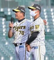 　ウエスタンリーグ優勝を決め、ネット裏のファンに向かってあいさつする阪神・平田２軍監督（左）。右は俊介＝甲子園（撮影・高部洋祐）