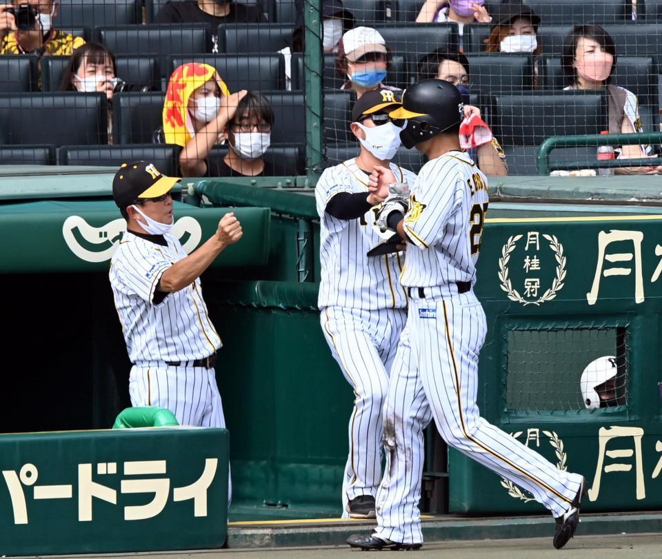 　２回、バッテリーエラーで勝ち越しの生還をした江越を迎える平田２軍監督（左）＝撮影・山口登