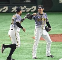 　２回、好守で盛り立てるマルテ（左）と笑顔でタッチを交わす西勇（撮影・飯室逸平）