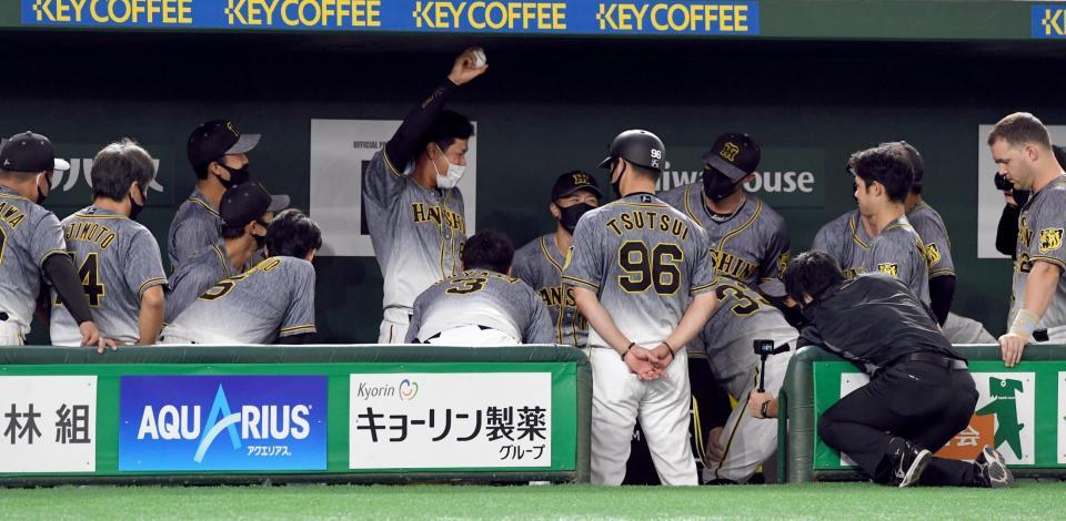 　試合前の円陣でボールを掲げ、声出しする佐藤輝（中央）＝撮影・佐藤厚