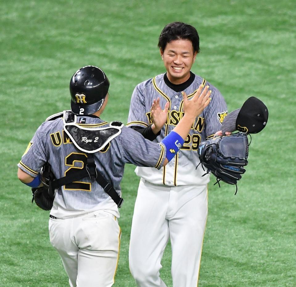 　プロ初完封で梅野（左）とタッチを交わす高橋（撮影・西岡正）