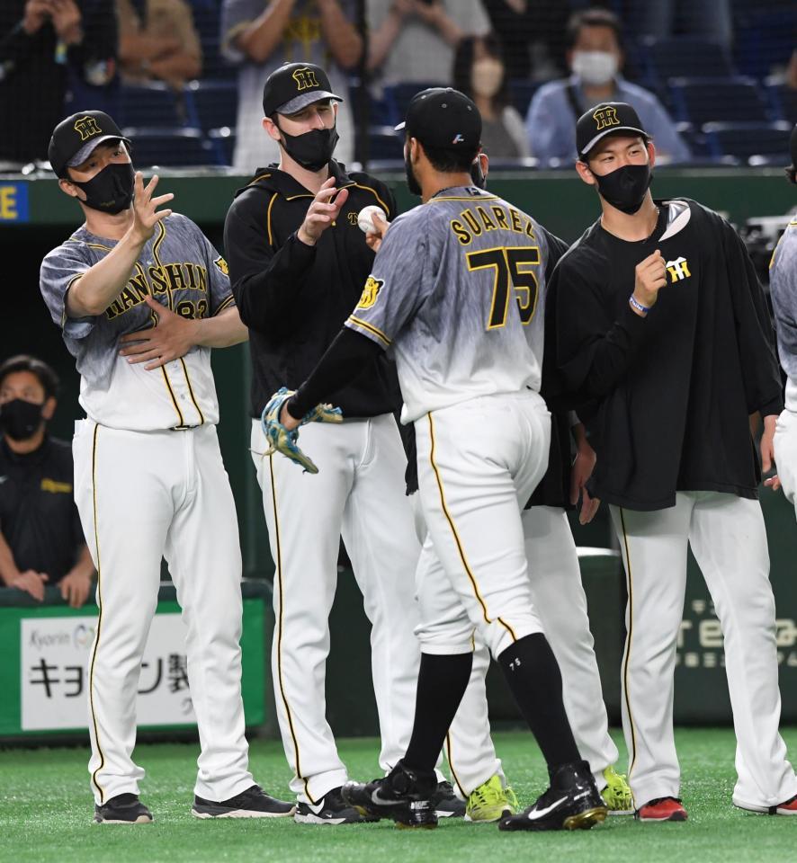 　６回１失点で８勝目を挙げ、スアレス（右から２人目）からウイニングボールを受け取るガンケル（左から２人目）＝撮影・佐藤厚