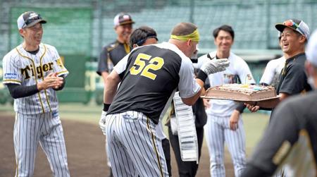 　誕生日ケーキを贈られ、矢野監督（左端）らナインから祝福されるサンズ（５２）