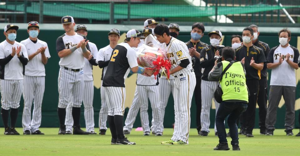 　梅野（中央左）から花束を贈られ、握手をする桑原（撮影・佐々木彰尚）