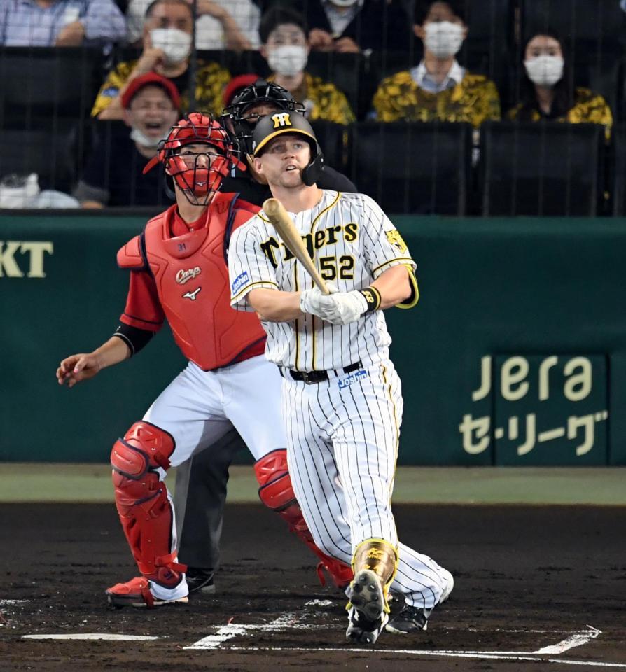 ２回阪神１死満塁、阪神ジェリー・サンズは左犠飛を放つ（捕手　広島・坂倉将吾）＝甲子園（撮影・山口登）