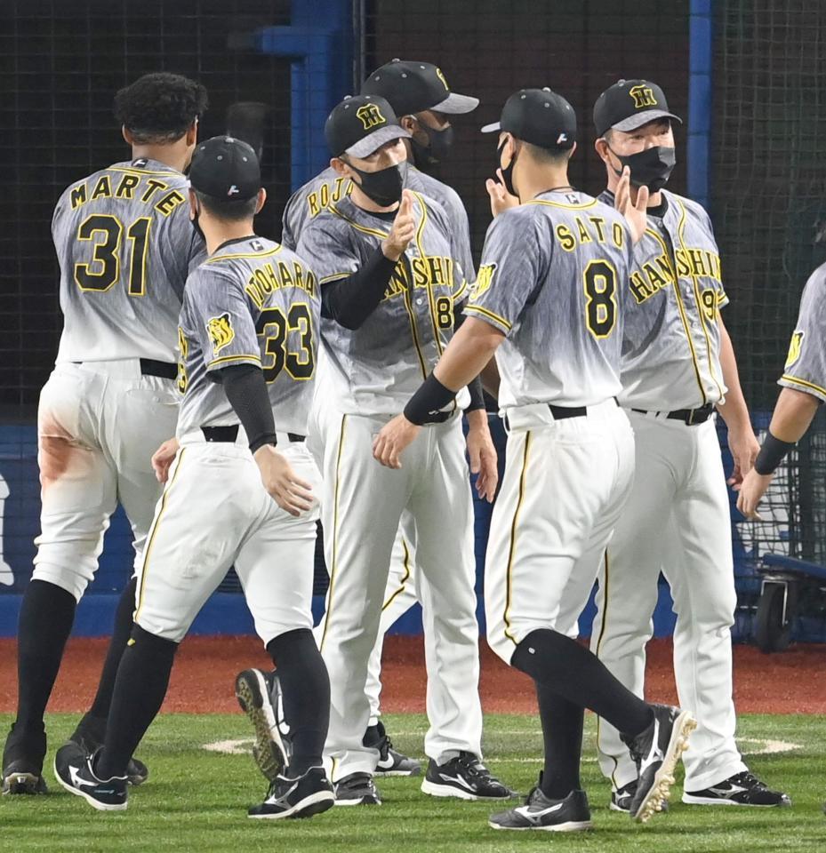 　ハイタッチでナインを迎える矢野監督（撮影・飯室逸平）