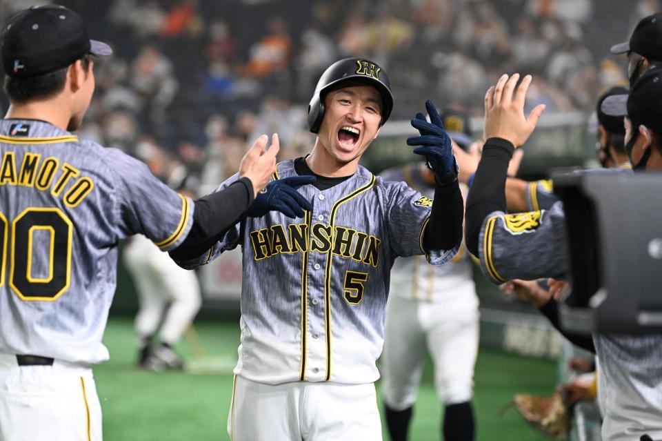 　９回、木浪の適時打で生還した近本はナインと歓喜する（撮影・田中太一）