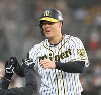 　３回、先制の生還を果たし、笑顔でタッチを交わす佐藤輝（撮影・飯室逸平）