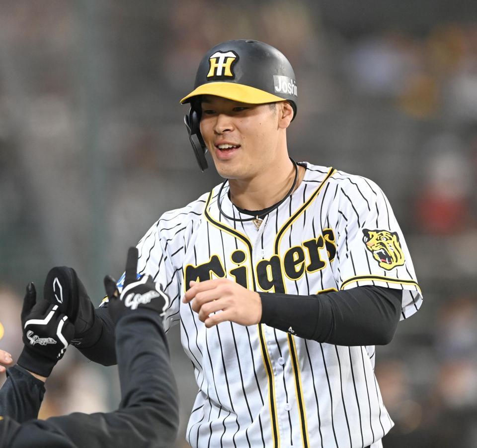 　３回、先制の生還を果たし、笑顔でタッチを交わす佐藤輝（撮影・飯室逸平）